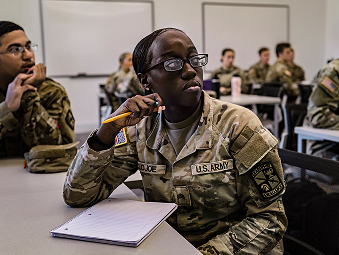 Female Soldier sitting at a table with a notepad in front of her