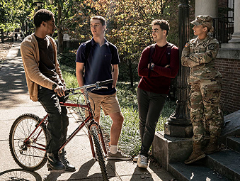 Four people standing outside and talking on a sunny day
