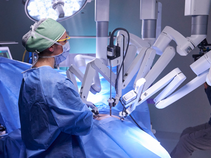 Una cirujana del Army usando un robot quirúrgico en un paciente durante un procedimiento 