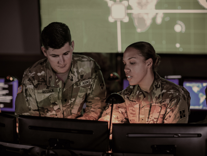 Soldados del Army Cyber frente a computadoras, trabajando dentro de un centro cibernético