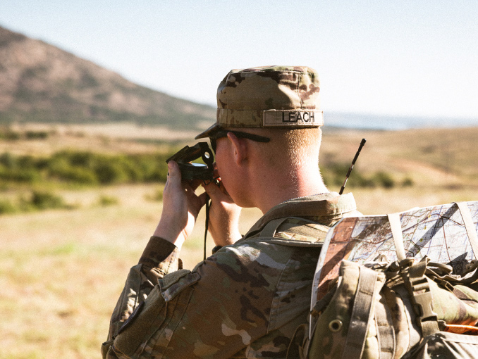 Un Soldado usando una brújula lensática durante un ejercicio de entrenamiento en un campo