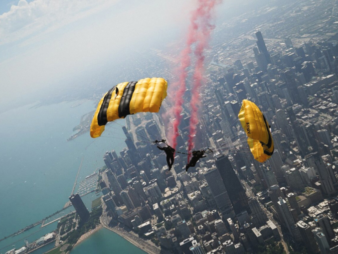 Two Golden Knights skydivers performing a jump over the city of Chicago