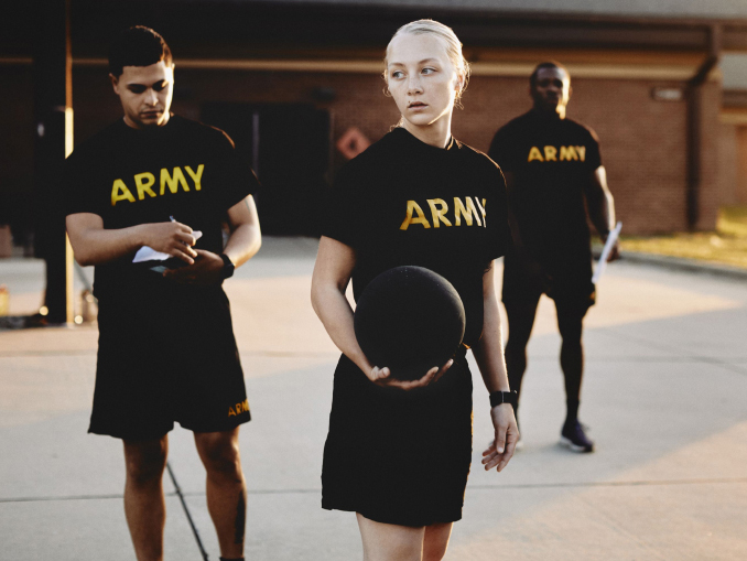 Dos hombres y una mujer con camisetas del Army preparándose para un examen de aptitud física 
