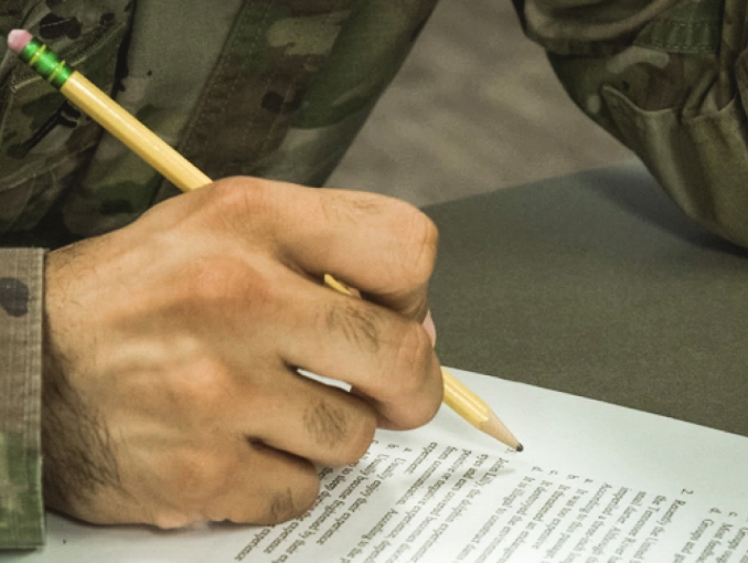 Closeup of the hand of a Soldier holding a pencil taking a test