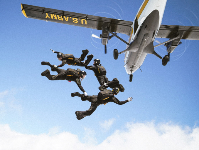 A group of Golden Knights skydivers jumping out of an airplane