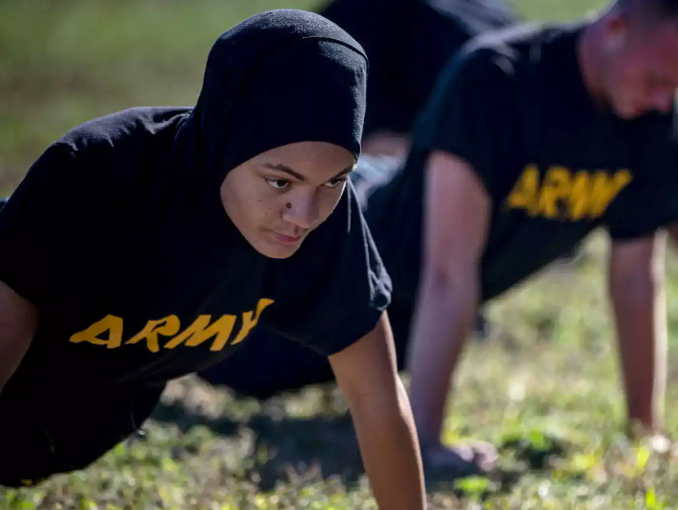 A female Soldier does push-ups while wearing a hair-covering garment