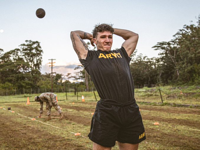 A U.S. Army Soldier conducts throws a 10-pound medicine ball backwards over his head