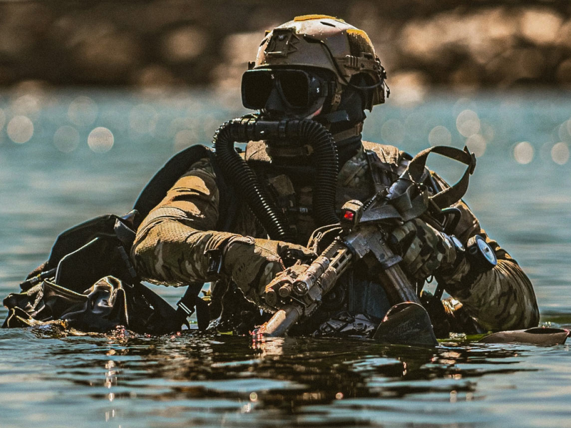 Un Green Beret vestido de buzo sale del agua durante una práctica de buceo