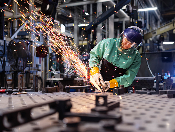 Sparks flying through the air as a welder works in a warehouse