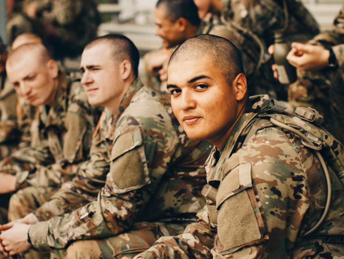 Soldados en uniforme de combate sentados en las gradas