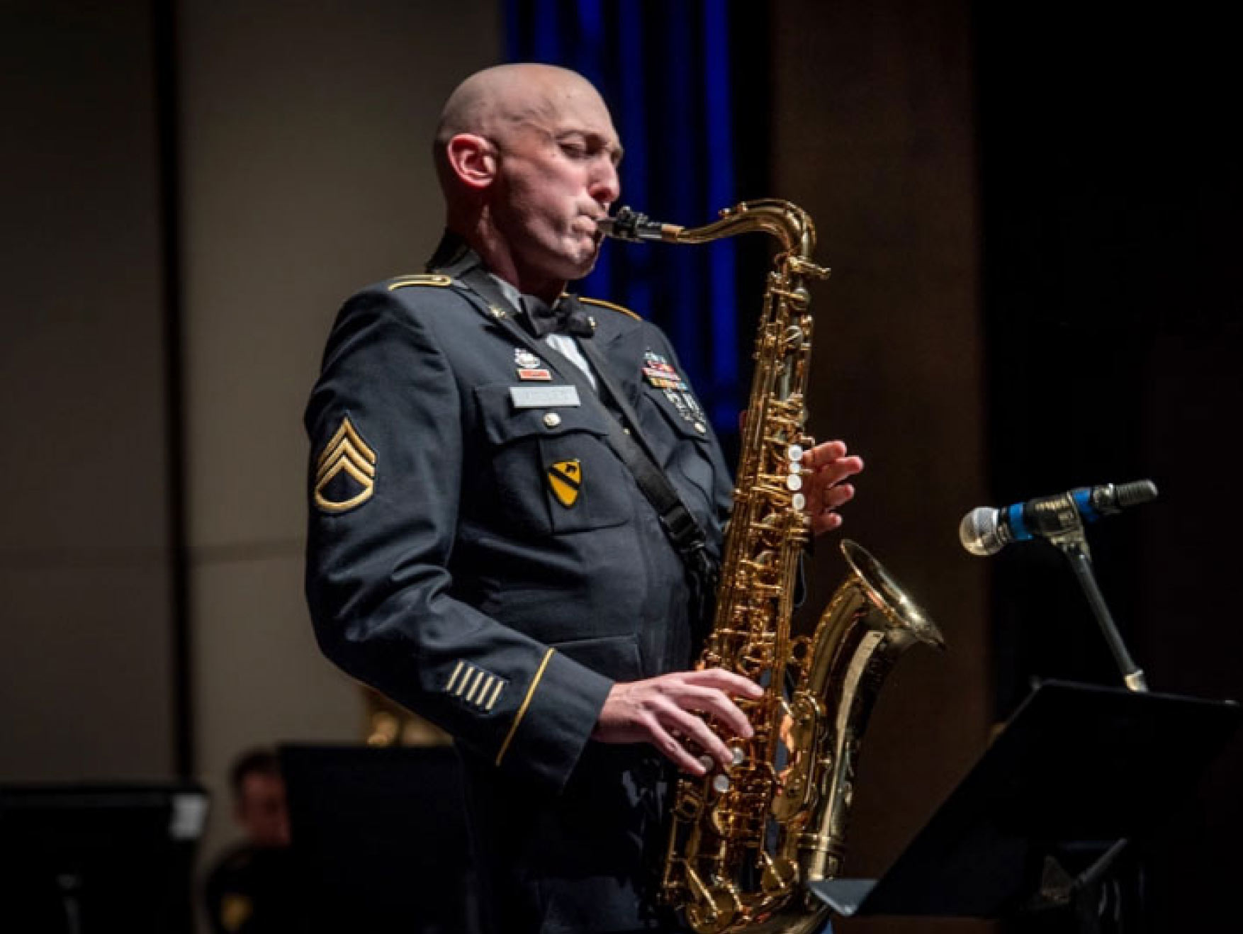 A Soldier playing a tenor saxophone on a stage