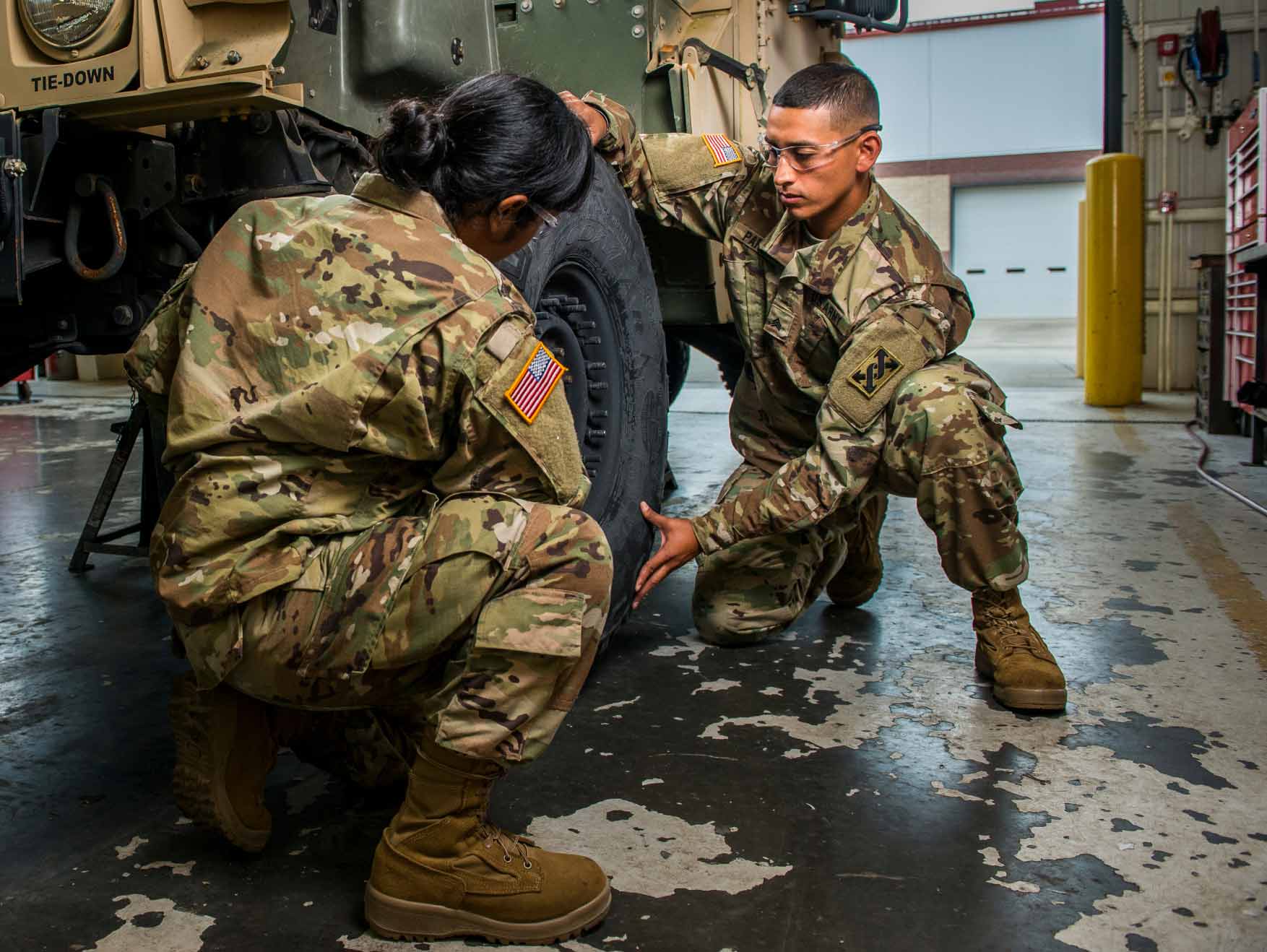 U.S. Army Reserve wheeled vehicle mechanics putting tires on a Military vehicle