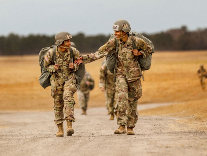 Dos Soldados en uniforme de combate caminando por un camino de tierra