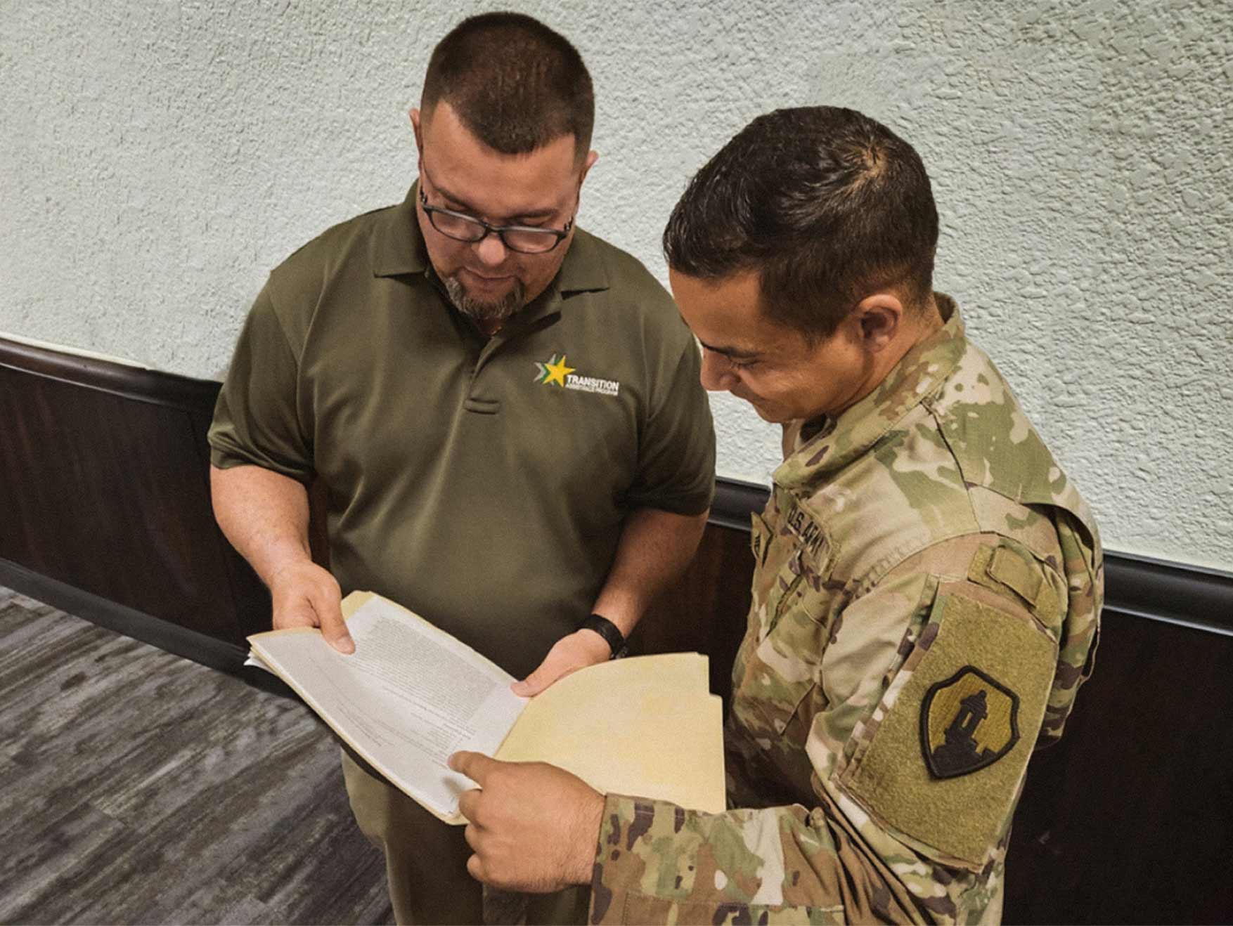 A Transition Services Specialist speaks to an Army Soldier at a job fair