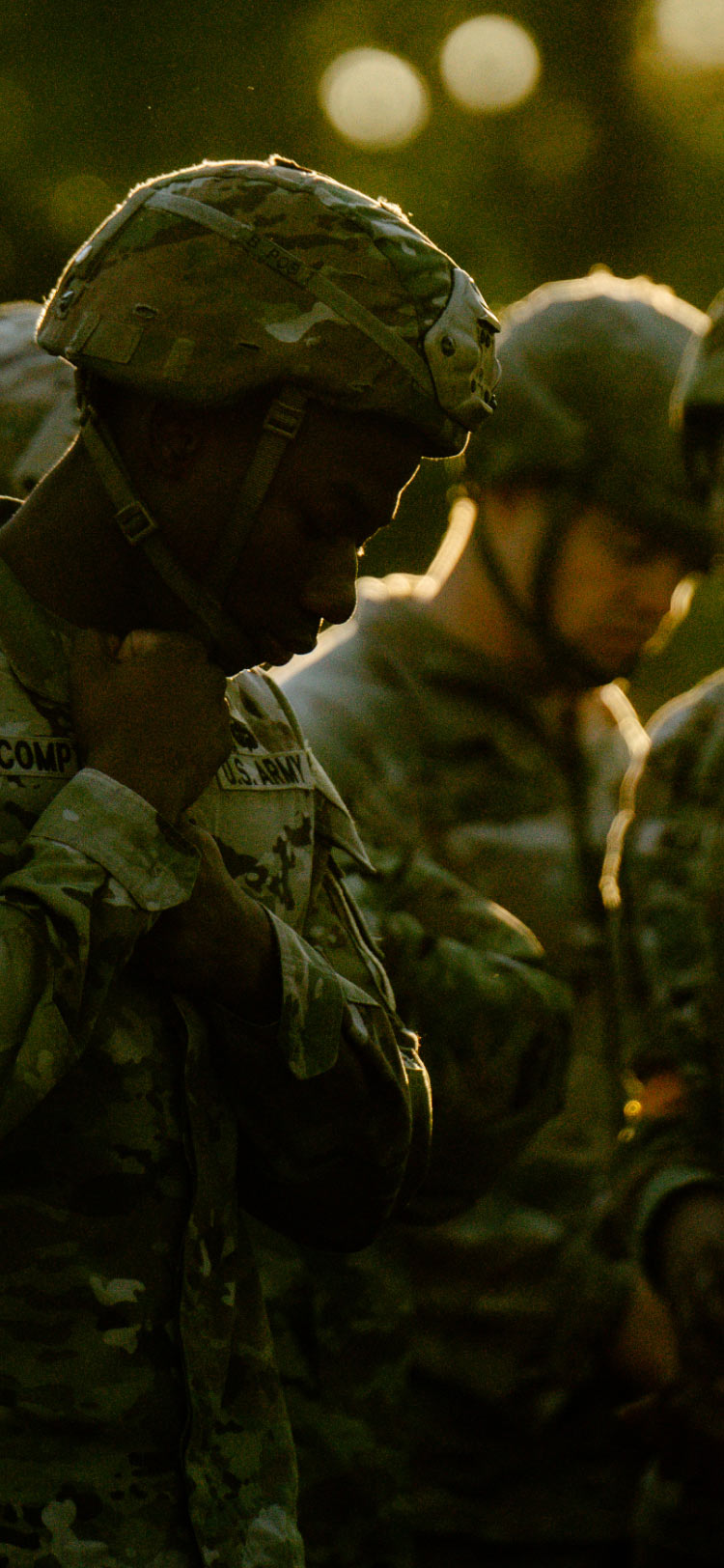 Un Soldado en uniforme de combate abrochando la correa de su casco